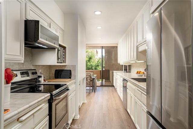 kitchen with stainless steel appliances, light wood finished floors, recessed lighting, backsplash, and tile countertops