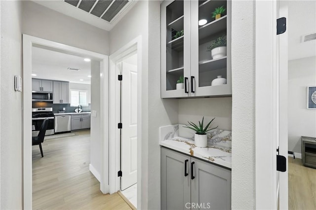 10641 Lindale St, Norwalk, CA 90650 - bar area with stainless steel appliances, light wood finished floors, baseboards, and decorative backsplash