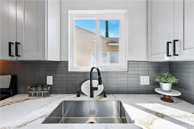 10641 Lindale St, Norwalk, CA 90650 - kitchen featuring a sink, white cabinetry, and backsplash
