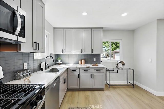 10641 Lindale St, Norwalk, CA 90650 - kitchen featuring stainless steel appliances, gray cabinetry, a sink, light wood finished floors, and recessed lighting