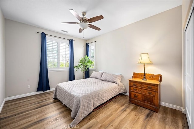 bedroom with wood finished floors, baseboards, and a ceiling fan