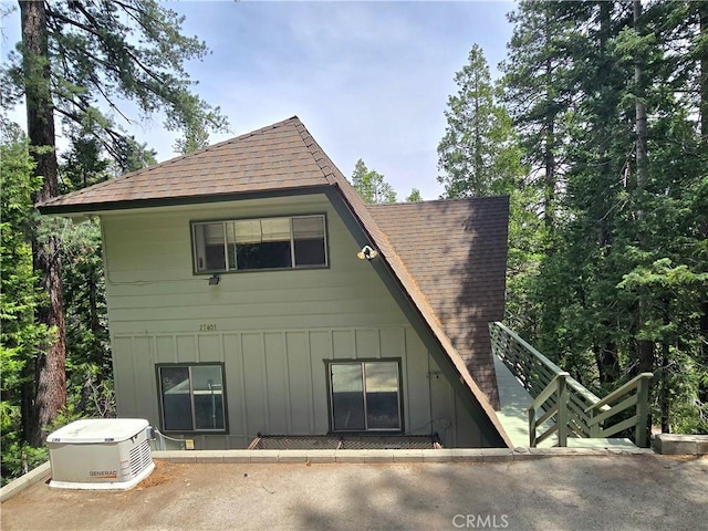 27403 Cottonwood Ln, Lake Arrowhead, CA 92317 - rear view of house with a shingled roof, board and batten siding, and a patio area