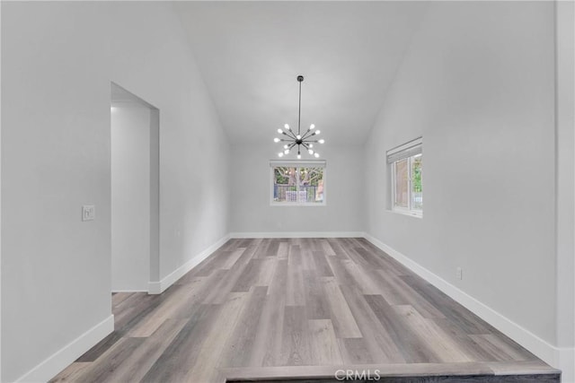 2612 Chauncy Pl, Riverside, CA 92506 - unfurnished dining area with a chandelier, wood finished floors, vaulted ceiling, and baseboards
