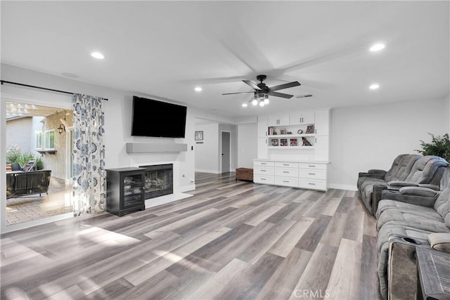 2612 Chauncy Pl, Riverside, CA 92506 - living area featuring light wood-style floors, recessed lighting, a ceiling fan, a fireplace with flush hearth, and baseboards
