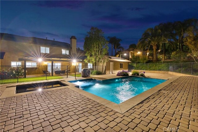 2612 Chauncy Pl, Riverside, CA 92506 - pool at night with a patio and fence
