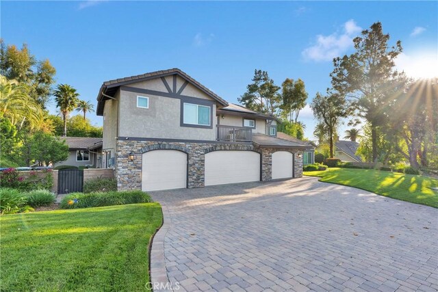 2612 Chauncy Pl, Riverside, CA 92506 - view of side of property featuring stucco siding, a garage, stone siding, and a lawn