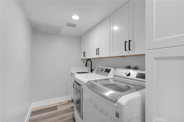 2612 Chauncy Pl, Riverside, CA 92506 - washroom with cabinet space, washer and dryer, light wood-style floors, and baseboards