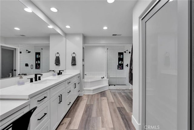 2612 Chauncy Pl, Riverside, CA 92506 - bathroom featuring double vanity, a shower stall, a bath, recessed lighting, and wood finished floors
