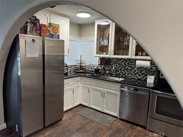 6045 Harding Ave, South Gate, CA 90280 - kitchen featuring stainless steel appliances, dark countertops, dark wood-style flooring, and tasteful backsplash