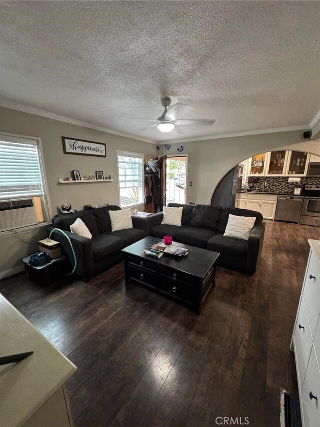 6045 Harding Ave, South Gate, CA 90280 - living room featuring ceiling fan, dark wood-style floors, crown molding, arched walkways, and a textured ceiling
