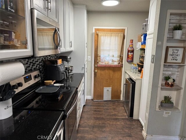 6045 Harding Ave, South Gate, CA 90280 - kitchen featuring appliances with stainless steel finishes, dark wood-style flooring, decorative backsplash, white cabinetry, and beverage cooler