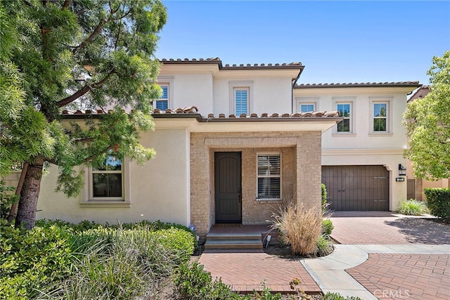 21 Fanpalm, Irvine, CA 92620 - mediterranean / spanish home featuring decorative driveway, a garage, stucco siding, and a tiled roof