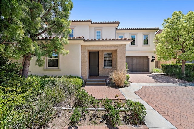 21 Fanpalm, Irvine, CA 92620 - mediterranean / spanish-style home with stucco siding, decorative driveway, a garage, and a tiled roof