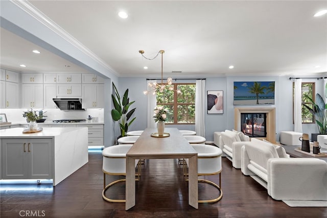 21 Fanpalm, Irvine, CA 92620 - dining room with healthy amount of natural light, crown molding, dark wood finished floors, recessed lighting, and a glass covered fireplace