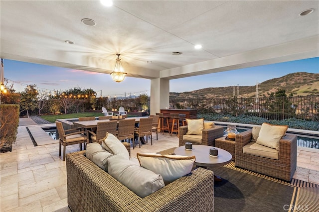 31740 Via Pamplona, San Juan Capistrano, CA 92675 - patio terrace at dusk featuring an outdoor hangout area, a mountain view, outdoor dining space, and a fenced backyard