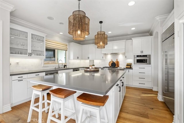 31740 Via Pamplona, San Juan Capistrano, CA 92675 - kitchen with stainless steel appliances, a kitchen island, dark countertops, a sink, and backsplash