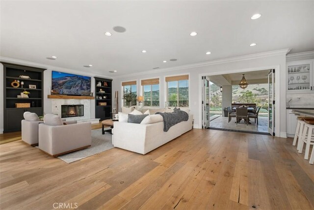 31740 Via Pamplona, San Juan Capistrano, CA 92675 - living area with crown molding, a fireplace, built in shelves, light wood-style flooring, and recessed lighting