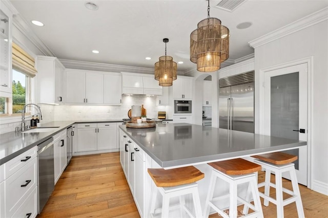 31740 Via Pamplona, San Juan Capistrano, CA 92675 - kitchen with stainless steel appliances, a sink, a spacious island, backsplash, and white cabinetry