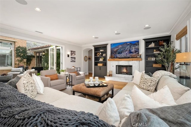 31740 Via Pamplona, San Juan Capistrano, CA 92675 - living area with ornamental molding, a warm lit fireplace, light wood-style flooring, built in features, and recessed lighting