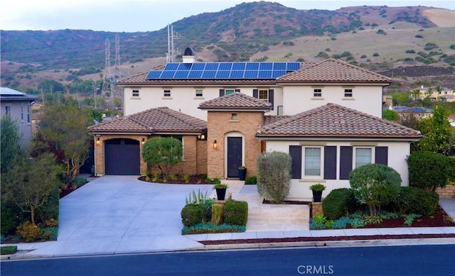 31740 Via Pamplona, San Juan Capistrano, CA 92675 - mediterranean / spanish house with stucco siding, concrete driveway, a garage, solar panels, and a mountain view