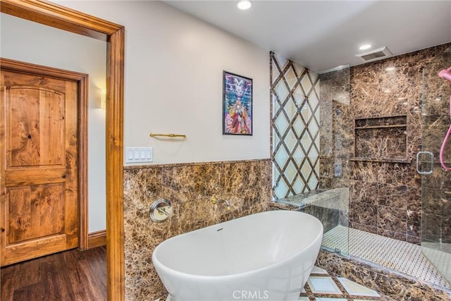 1585 E Ocean Blvd, Newport Beach, CA 92661 - bathroom featuring tile walls, a soaking tub, a shower stall, wood finished floors, and wainscoting