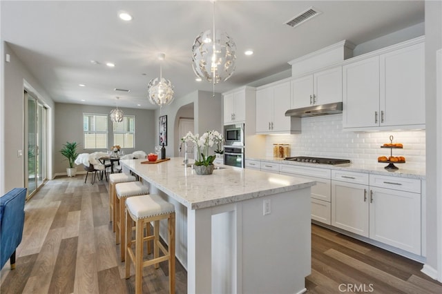 4530 E Langdon Dr, Anaheim Hills, CA 92807 - kitchen featuring appliances with stainless steel finishes, white cabinets, decorative backsplash, arched walkways, and recessed lighting