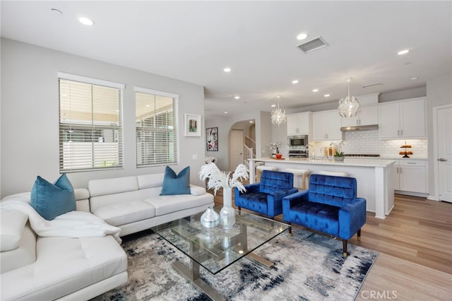 4530 E Langdon Dr, Anaheim Hills, CA 92807 - living room with arched walkways, recessed lighting, and light wood finished floors