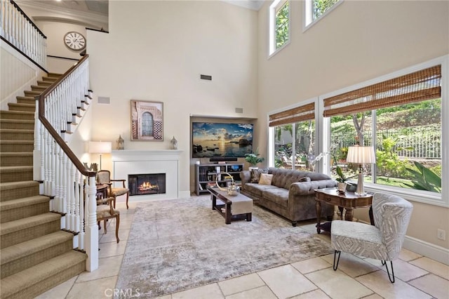 23478 Ridgeway, Mission Viejo, CA 92692 - living room with a high ceiling, a lit fireplace, stairway, baseboards, and ornamental molding