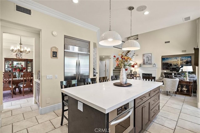 23478 Ridgeway, Mission Viejo, CA 92692 - kitchen featuring a breakfast bar area, light countertops, hanging light fixtures, crown molding, and a chandelier