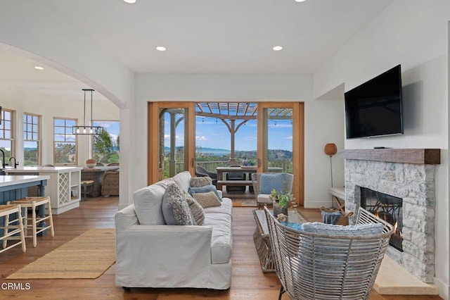 101 Via Tusa, Santa Barbara, CA 93105 - living area featuring plenty of natural light, arched walkways, a stone fireplace, recessed lighting, and wood finished floors