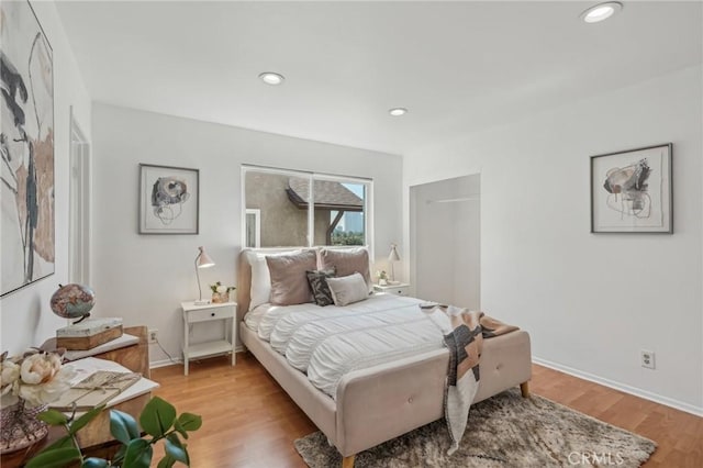 bedroom featuring light wood-type flooring, recessed lighting, and baseboards