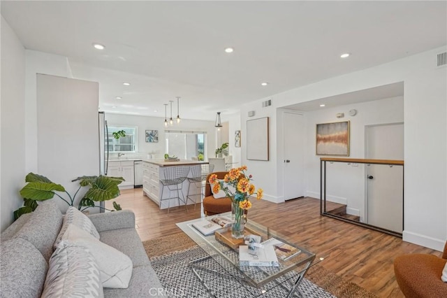 living area with light wood finished floors, recessed lighting, and baseboards