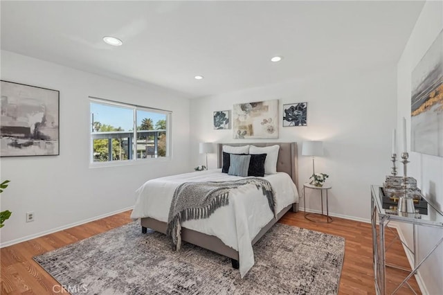 bedroom with wood finished floors, recessed lighting, and baseboards