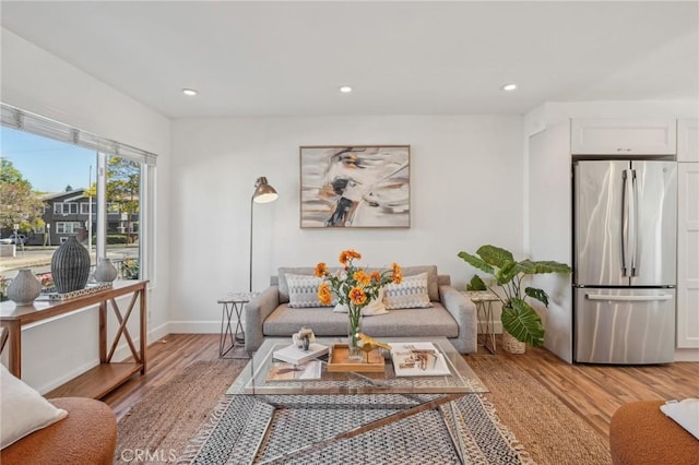 living room with light wood-type flooring, recessed lighting, and baseboards
