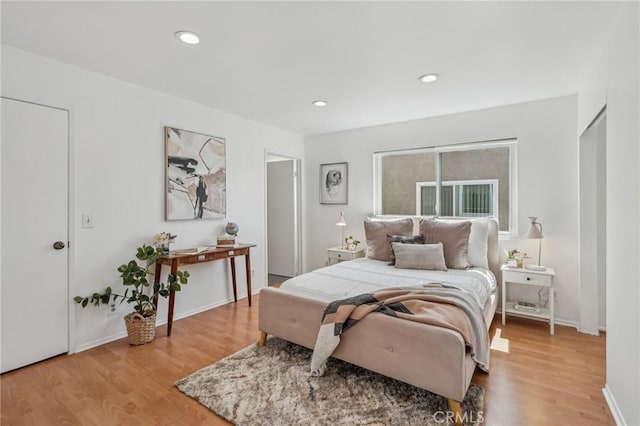 bedroom with light wood-style flooring, baseboards, and recessed lighting