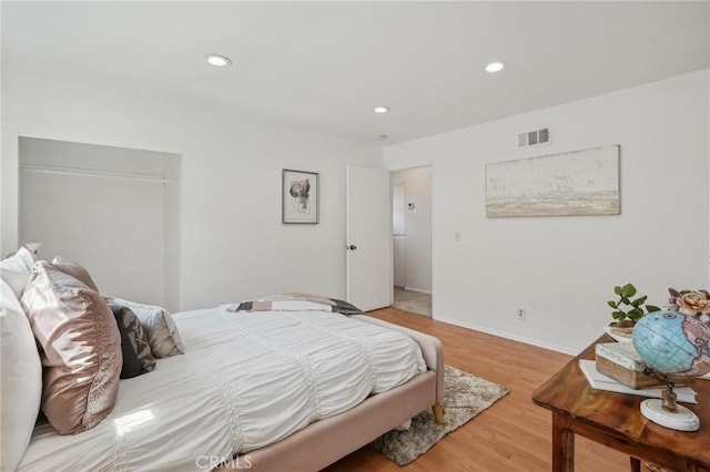 bedroom with wood finished floors, recessed lighting, and baseboards