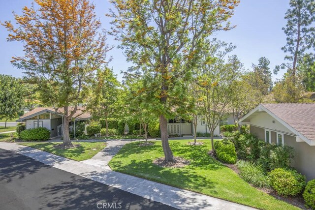 829 Via Alhambra Unit A, Laguna Woods, CA 92637 - obstructed view of property featuring stucco siding and a front lawn