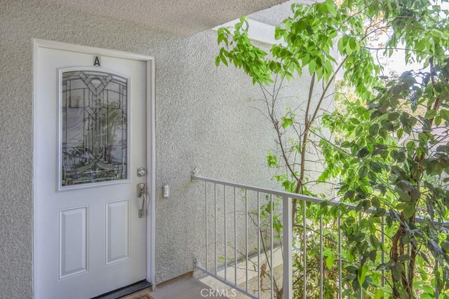 829 Via Alhambra Unit A, Laguna Woods, CA 92637 - doorway to property featuring stucco siding and a balcony