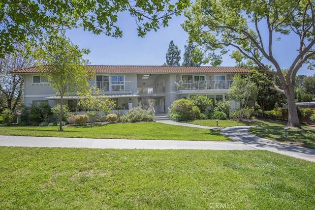 829 Via Alhambra Unit A, Laguna Woods, CA 92637 - view of front of home featuring a balcony, a front yard, stucco siding, and a tile roof