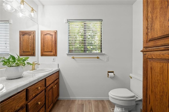 5456 Edith Ave, Corning, CA 96021 - bathroom with double vanity, toilet, wood finished floors, and baseboards