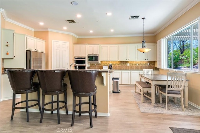 5799 Buckthorn Ave, Rancho Cucamonga, CA 91737 - kitchen featuring appliances with stainless steel finishes, dark countertops, a breakfast bar, backsplash, and light wood finished floors