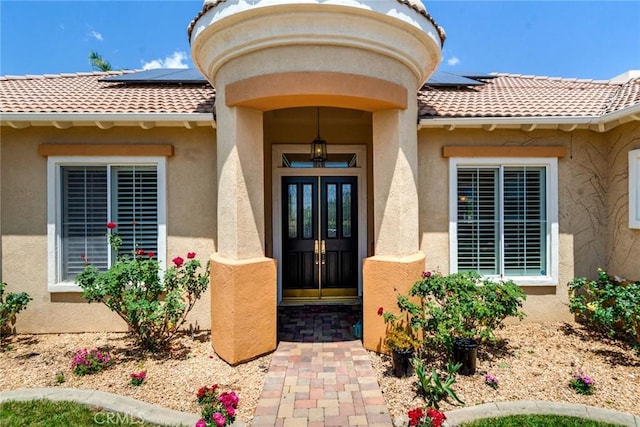 5799 Buckthorn Ave, Rancho Cucamonga, CA 91737 - doorway to property featuring solar panels, french doors, stucco siding, and a tiled roof