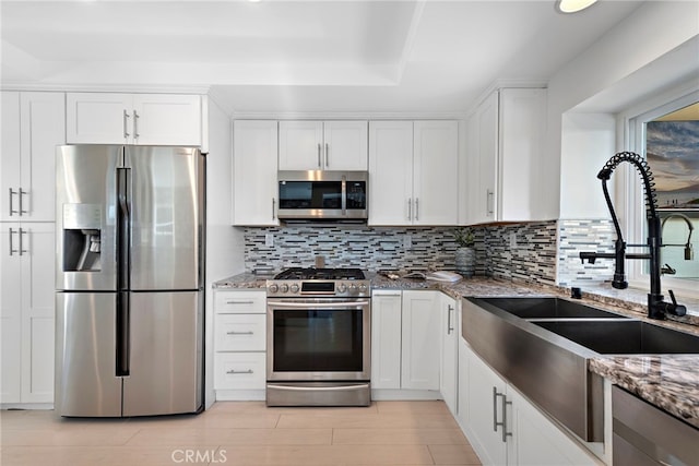 2 Hyannis, Laguna Niguel, CA 92677 - kitchen with appliances with stainless steel finishes, a sink, white cabinetry, and backsplash