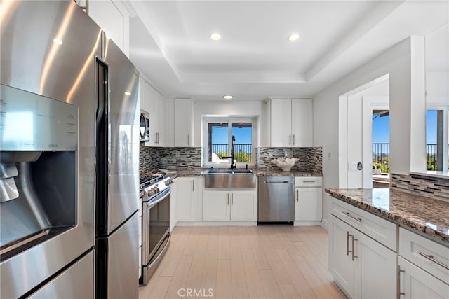 2 Hyannis, Laguna Niguel, CA 92677 - kitchen with appliances with stainless steel finishes, a sink, a raised ceiling, backsplash, and white cabinets