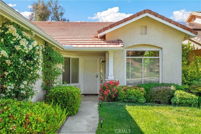 32364 Corte Coronado, Temecula, CA 92592 - view of exterior entry featuring a tiled roof, stucco siding, and a lawn
