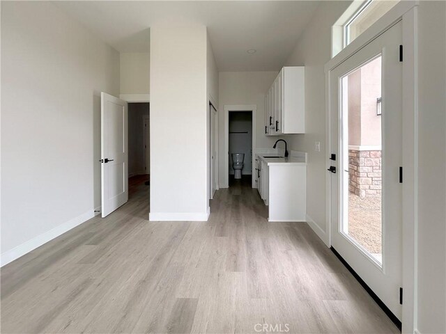 12460 San Marcos Rd, Atascadero, CA 93422 - kitchen with plenty of natural light, light wood-style floors, white cabinetry, and light countertops