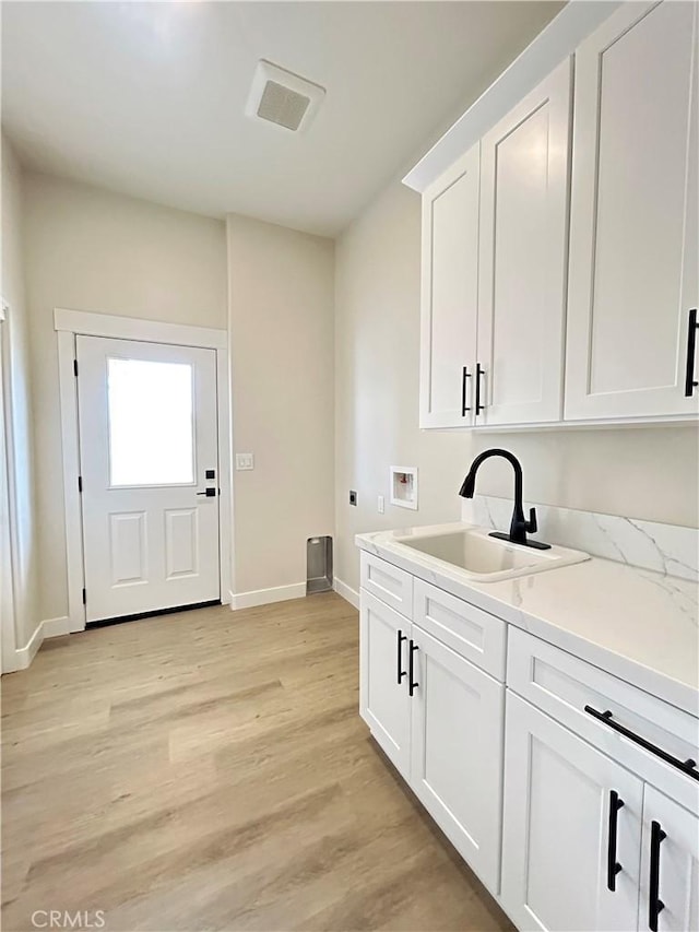 12460 San Marcos Rd, Atascadero, CA 93422 - washroom with hookup for a washing machine, hookup for an electric dryer, light wood-style flooring, and cabinet space