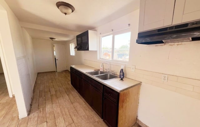 1324 Murdock St, Bakersfield, CA 93307 - kitchen featuring a sink, under cabinet range hood, light countertops, and light wood-style floors