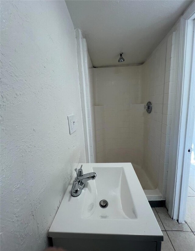 1324 Murdock St, Bakersfield, CA 93307 - full bath featuring tile patterned flooring, a sink, a textured wall, and tiled shower