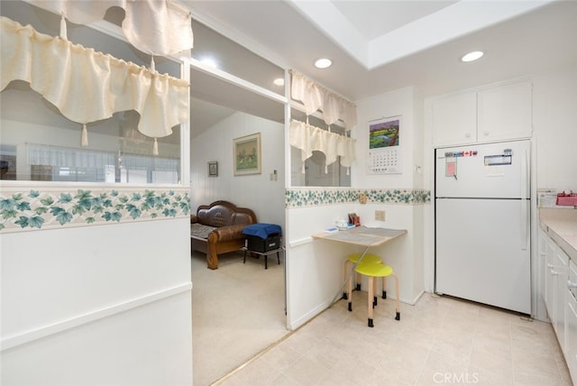 kitchen featuring freestanding refrigerator, recessed lighting, white cabinets, and light countertops